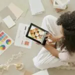 Woman in White Shirt Holding Black Tablet Computer